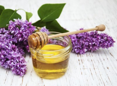 Lilac flowers with honey  on a wooden background